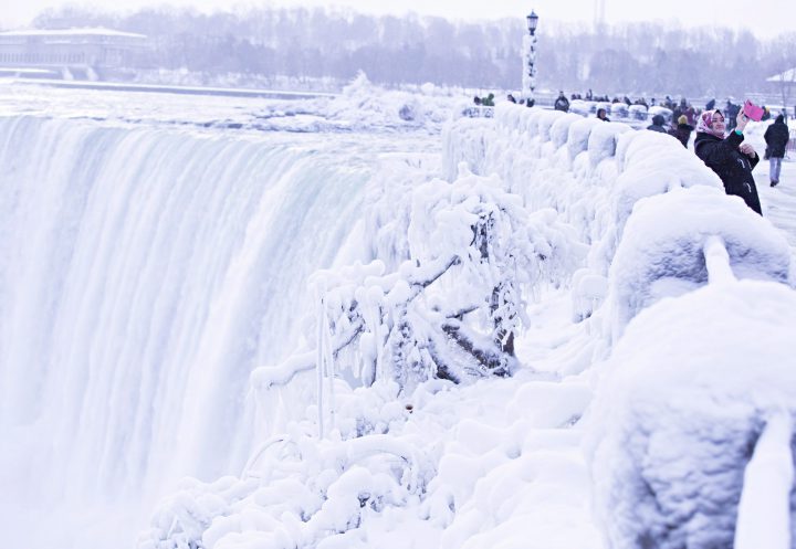 Visitors take photographs at the brink of the Horseshoe Falls in Niagara Falls, Ont., as cold weather continues through much of the province on Friday.