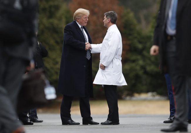 President Donald Trump shakes hands with White House physician Dr. Ronny Jackson as he boards Marine One as he leaves Walter Reed National Military Medical Center in Bethesda, Md., Jan. 12, 2018, .