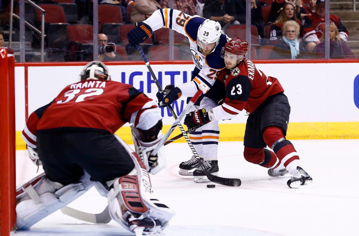 Arizona Coyotes defenseman Oliver Ekman-Larsson (23) shoves Edmonton Oilers center Leon Draisaitl (29) off his shot as Coyotes goaltender Antti Raanta (32) waits for the puck during the first period of an NHL hockey game, Friday, Jan. 12, 2018, in Glendale, Ariz. (AP Photo/Ross D. Franklin).