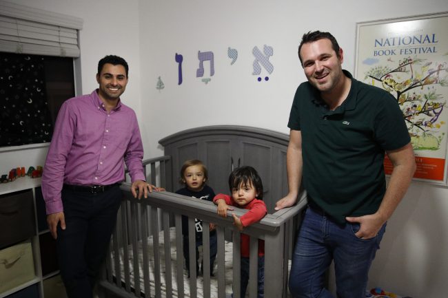 Elad Dvash-Banks, left, and his partner, Andrew, pose for photos with their twin sons, Ethan, center right, and Aiden in their apartment , Jan. 23, 2018, in Los Angeles. 


