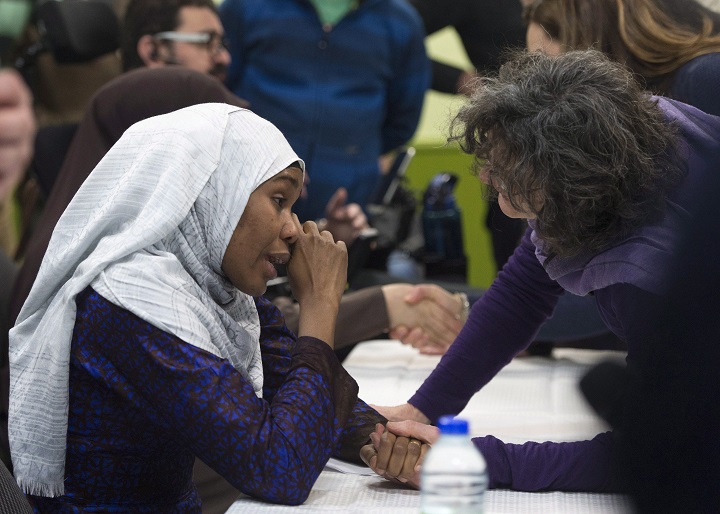 Idiatou Barry, left, wipes her eyes as she speaks with a woman during a gathering at the Centre Islamique de Quebec, marking the first anniversary of the mosque shooting, Saturday, January 27, 2018 in Quebec City. Barry lost her husband, Mamadou Tanou Barry, in the shooting.