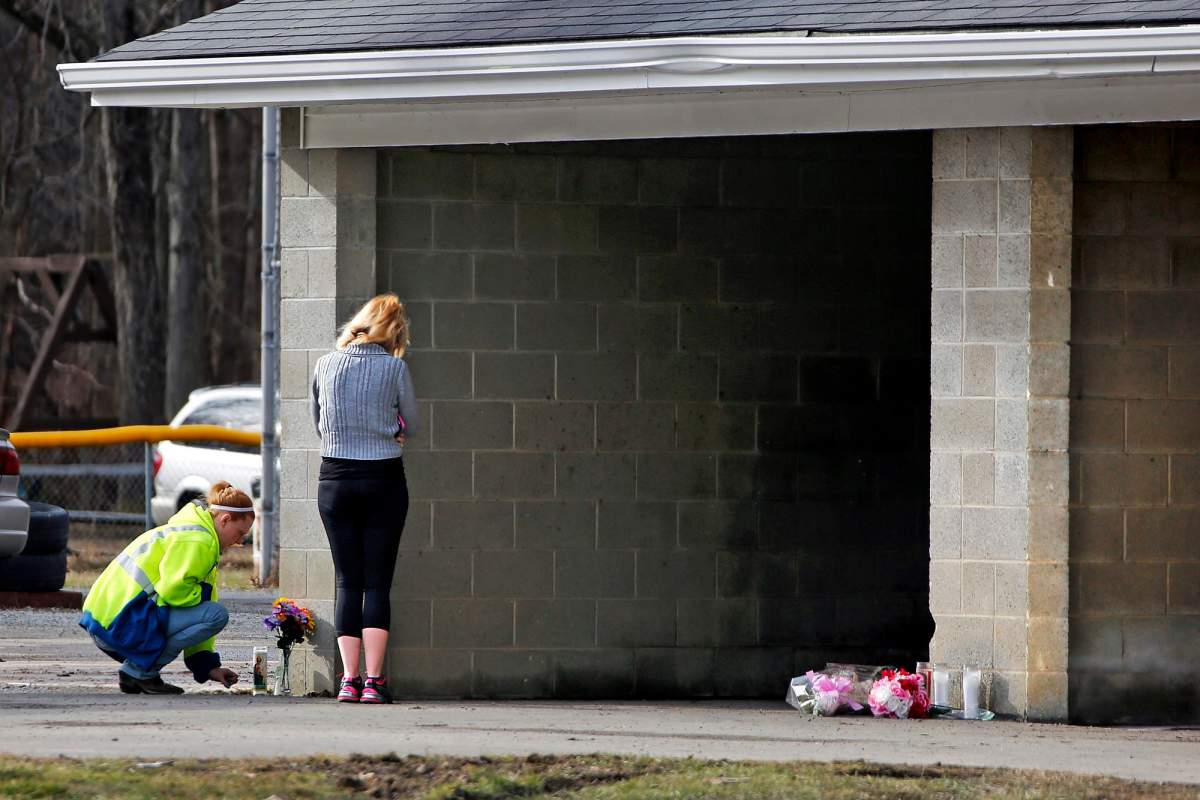 Flowers and a candle are placed at Ed's Car Wash in Melcroft, Pa., on Monday, Jan. 29, 2018. Pennsylvania State Police said a man armed with a semi-automatic rifle, a .308 rifle and a handgun, opened fire at the car wash around 3am Sunday morning killing four people.