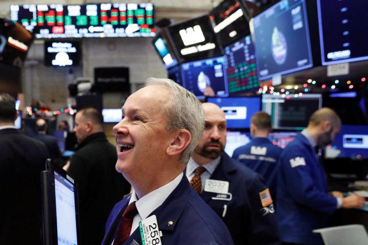 A trader laughs as the Dow Jones Industrial Average rises above 25,000 on the floor of the New York Stock Exchange shortly after the opening bell in New York, U.S., January 4, 2018.  REUTERS/Lucas Jackson.