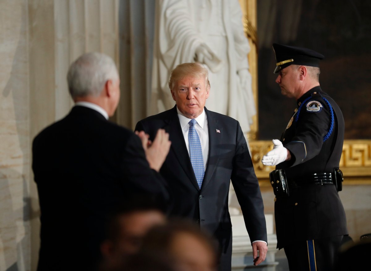 U.S. President Donald Trump is applauded by Vice President Mike Pence as he arrives in the Capitol Rotunda for a Congressional Gold Medal ceremony honoring former Senate majority leader Bob Dole in Washington, U.S., January 17, 2018.