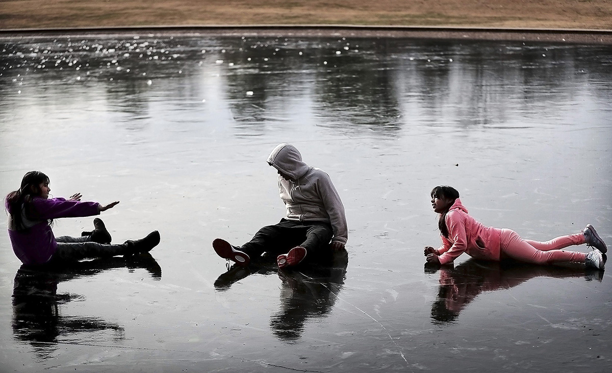 Sherlin Galicia, left, Alexander Galicia, center, and Heidi Galicia play on the iced over pond at Overton Park while walking the dog, Tuesday afternoon, Jan. 2, 2018, in Memphis, Tenn.