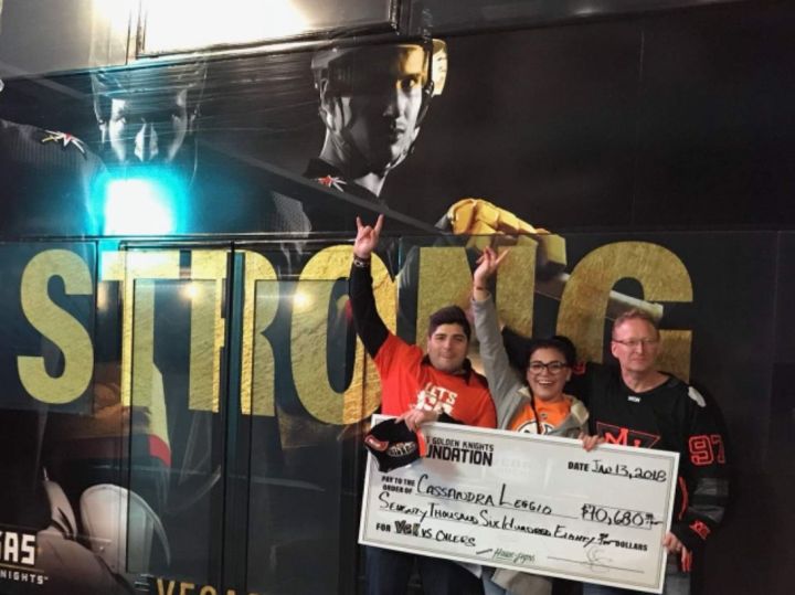 Julio Rojo (left), Cassie Leggio (centre) and Rod Rousseau (right) hold a fake check after winning the Golden Knights’ 51/49 prize in Las Vegas on Jan. 13, 2018.