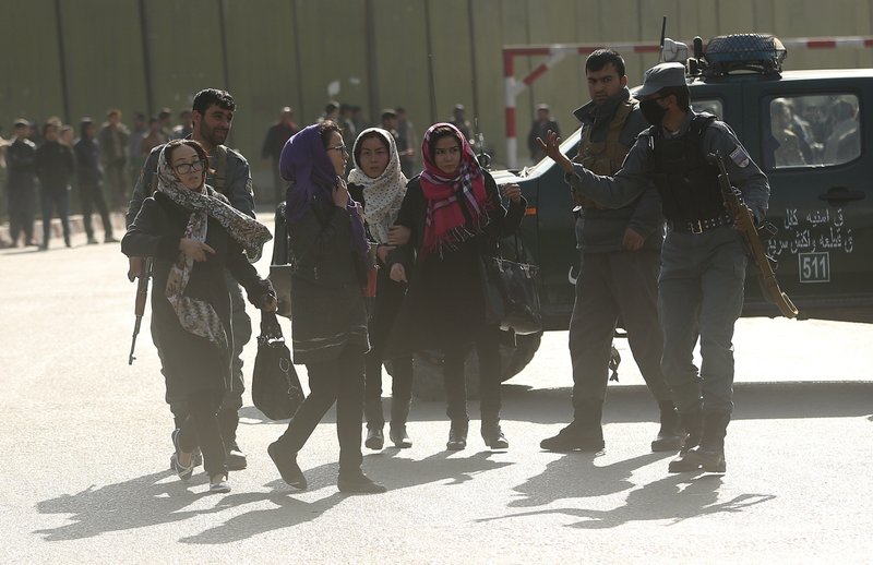 Women try to enter the site of a deadly suicide attack to look for relatives in downtown Kabul, Afghanistan, Saturday, Jan. 27, 2018.
