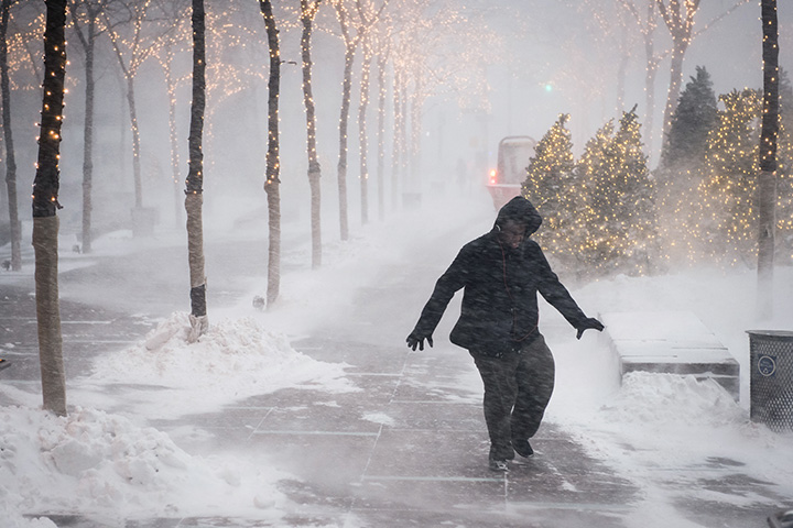 A pedestrian slips while walking in strong winds during a snow storm in New York on Thursday, Jan. 4, 2018.
