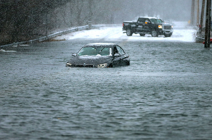 A car is surrounded by storm surge in Marshfield, Mass., on Jan. 4, 2018.