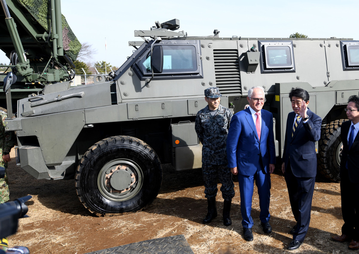 Visiting Australian Prime Minister Malcolm Turnbull (2nd L) holds a photo session with Japanese Prime Minister Shinzo Abe (C) in front of an Australian-made Bushmaster protected mobility vehicle while visiting the Japan Ground Self Defense Forces' Narashino camp in Funabashi, Chiba on January 18, 2018.