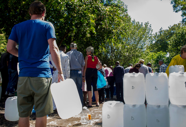 In this photo taken Tuesday, Jan. 23, 2018, people queue for water at a natural spring in Cape Town, South Africa.