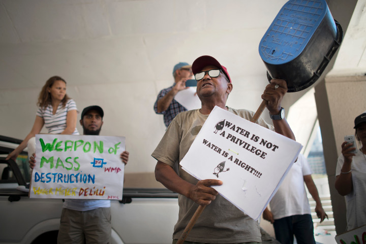 A man addresses hundreds of people taking part in a protest against the way the Cape Town city council has dealt with issues around water shortages, on January 28, 2018.
