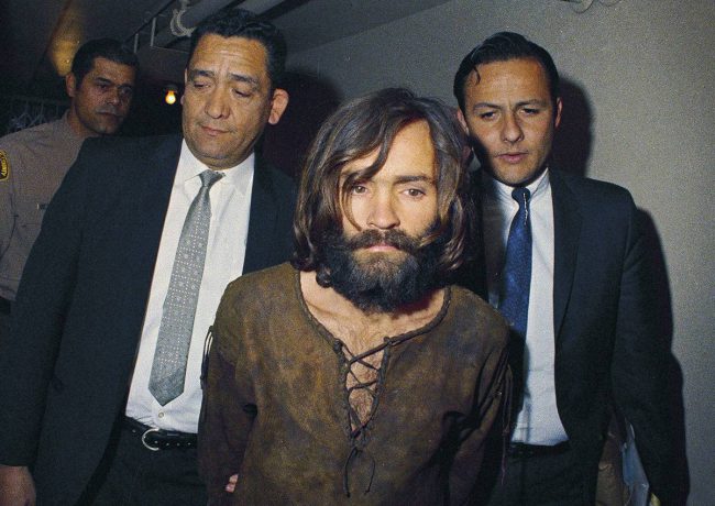 In this 1969 file photo, Charles Manson is escorted to his arraignment on conspiracy-murder charges in connection with the Sharon Tate murder case. 