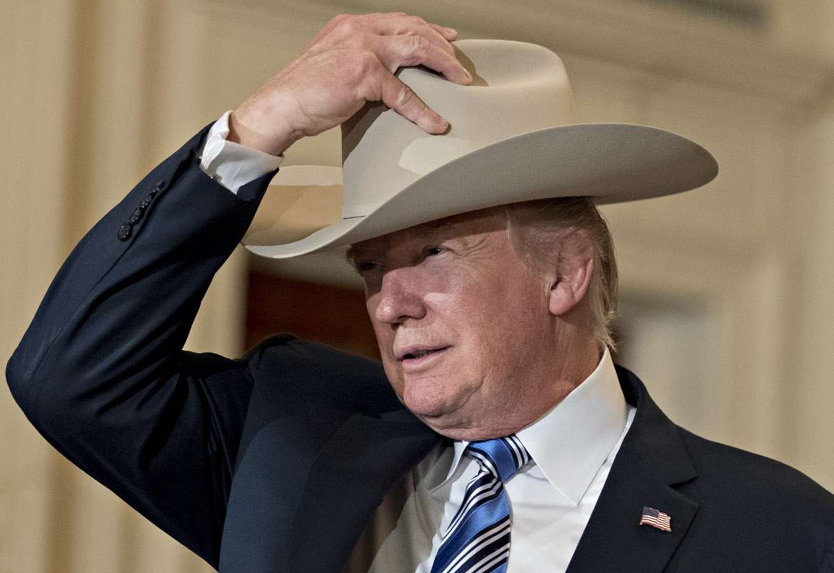 Donald Trump puts on a Stetson cowboy hat while participating in a Made in America event, with companies from 50 states featuring their products, in the East Room of the White House in Washington, D.C., U.S., on Monday, July 17, 2017. 