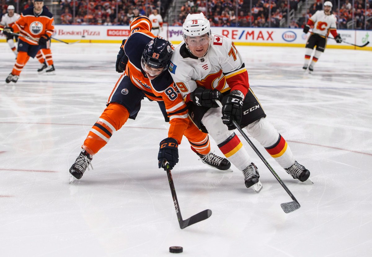 Calgary Flames left wing Micheal Ferland (79) and Edmonton Oilers defenceman Matt Benning (83) battle for the puck during first period NHL action in Edmonton, Alta., on Thursday January 25, 2018. THE CANADIAN PRESS/Jason Franson.
