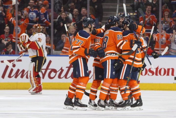 Calgary Flames goaltender David Rittich (33) skates past as the Edmonton Oilers celebrate a goal during third period NHL action in Edmonton, Alta., on Thursday January 25, 2018. 