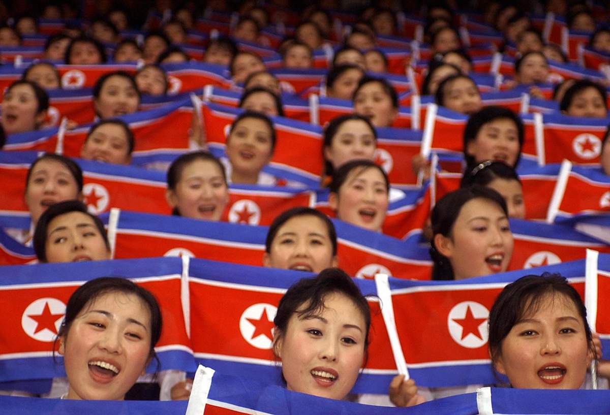North Korean cheer team members wave their national flags during the World Students Games opening ceremony in Daegu on 21 August 2003. AFP PHOTO/KIM Jae-Hwan (Photo credit should read KIM JAE-HWAN/AFP/Getty Images)
