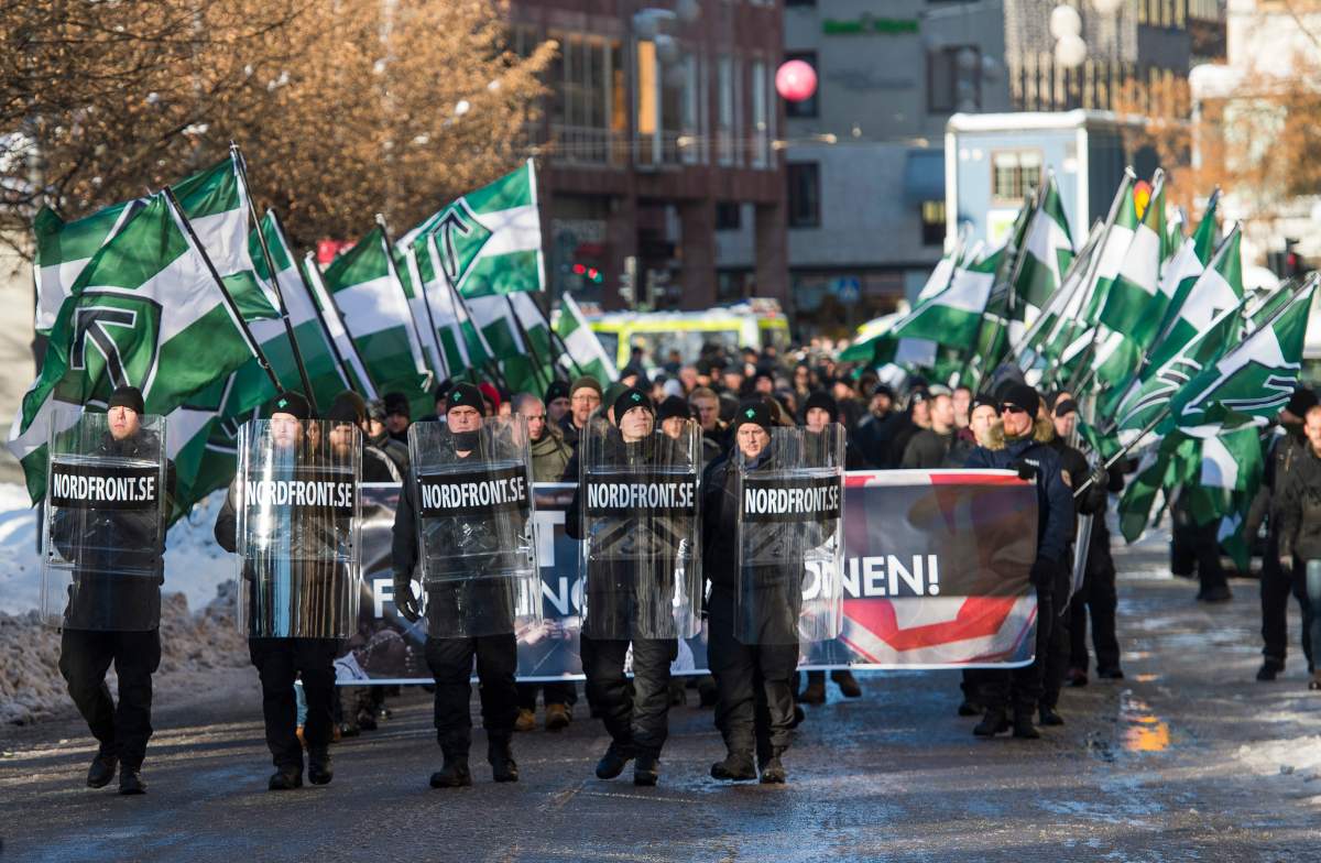 The neo-nazi Nordic Resistance Movement demonstrate in central Stockholm using the Tyr rune symbol on November 12, 2016 to protest against migrants.