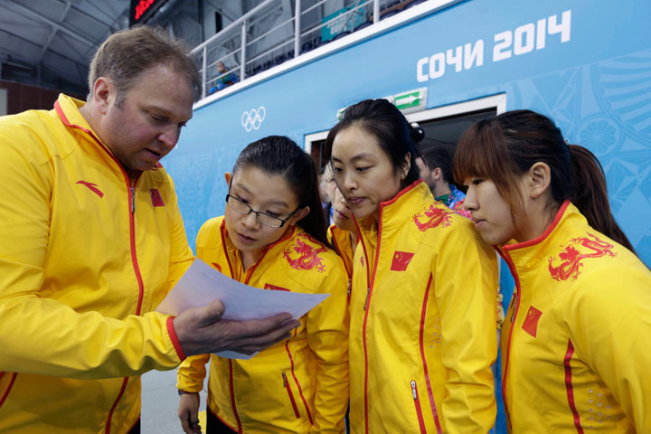 Team China coach Marcel Rocque, of Canada, talks with his players, from left, Wang Bingyu, Yue Qingshuang, and Jiang Yilun, after the first day of curling training at the 2014 Winter Olympics, Saturday, Feb. 8, 2014, in Sochi, Russia.