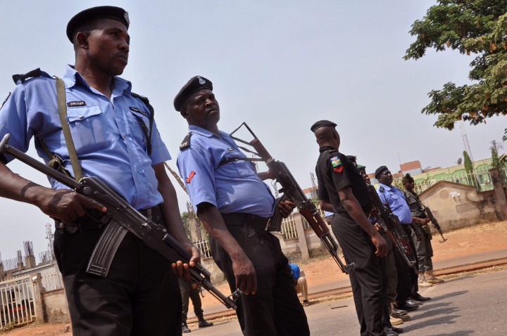 In this Saturday Feb. 7, 2015 file photo, Nigeria police officers block a road in the city of Abuja, Nigeria. 