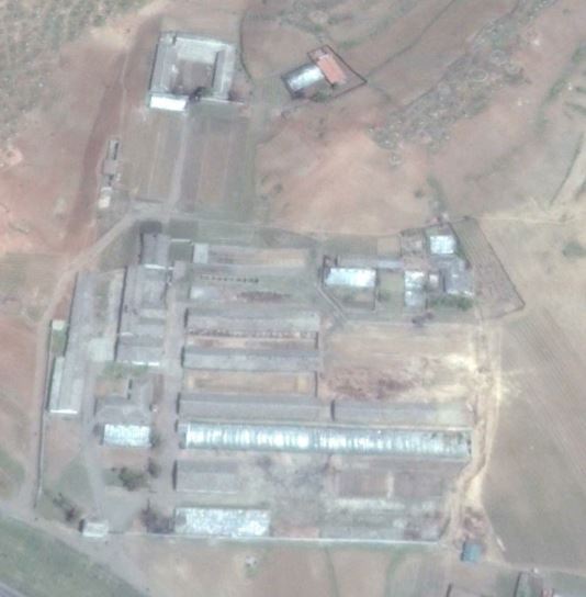 A satellite image of a small building complex in Tokchon, North Korea that researchers say shows damage following a missile test failure. Note the area around the courtyard and possible damage to a long, brown-roofed building just below it.