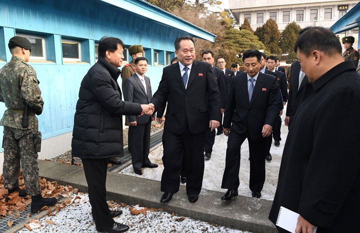 Head of North Korean delegation Ri Son Gwon, chairman of the Committee for the Peaceful Reunification of the Country (CPRC) of DPRK, shakes hands with a South Korean official as he crosses the concrete border to attend their meeting at the truce village of Panmunjom in the demilitarized zone separating the two Koreas, South Korea, Jan. 9, 2018. 