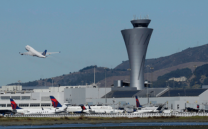 In this Oct. 24, 2017 file photo, the air traffic control tower is in sight as a plane takes off from San Francisco International Airport. 
