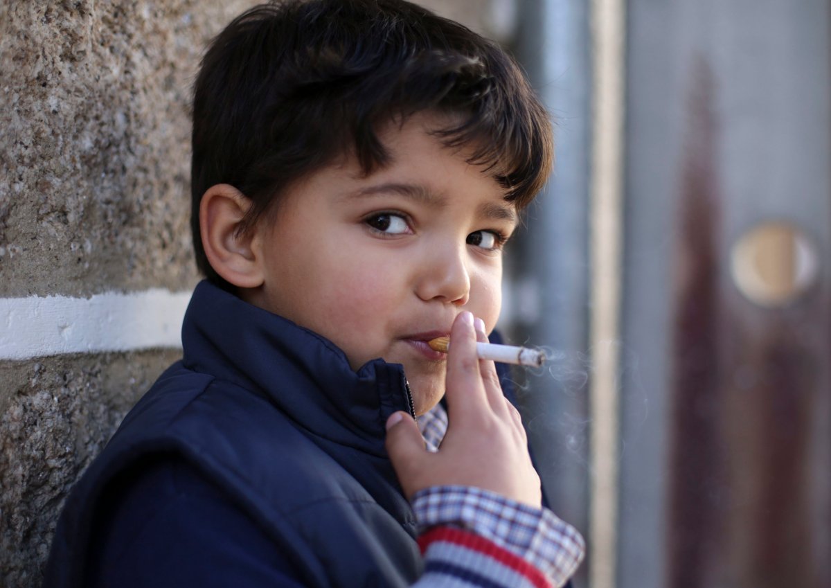 Fernando, 6-years-old, smokes a cigarette in the village of Vale de Salgueiro, northern Portugal, during the local Kings' Feast Saturday, Jan. 6, 2018. 