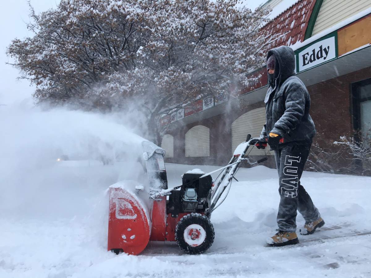 A worker using a snowblower to clear snow outside United Cycle in Edmonton, Alta. following an overnight snowfall. January 26, 2018.