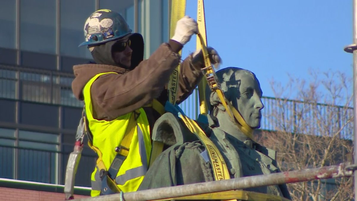 Crews from Halifax Regional Municipality wrapped the statue in yellow straps before lifting it onto a flatbed truck. 