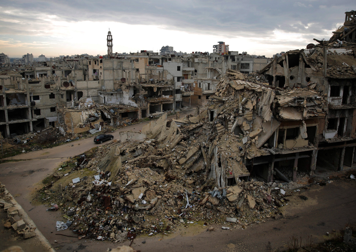 In this Tuesday, Jan. 16, 2018 photo, a car drives through a devastated part of the old city of Homs, Syria.