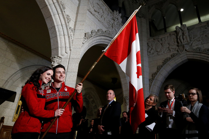 Ice dancers Tessa Virtue and Scott Moir pose with a flag after being named Canada's flag-bearers for the opening ceremony of the 2018 Pyeongchang Winter Olympic Games during an event on Parliament Hill in Ottawa, Jan. 16, 2018.
