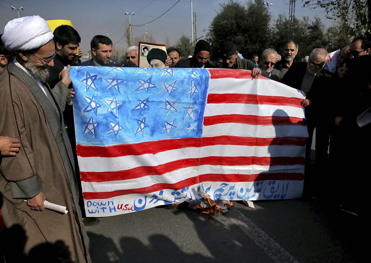 Iranian worshippers burn a representation of U.S. flag, reading "the most deserving flag for burning", during a rally against anti-government protestors after the Friday prayer ceremony in Tehran, Iran, Jan. 5, 2018. 