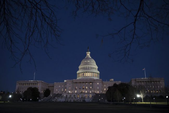 The U.S. Capitol is illuminated in Washington, Friday evening, Jan. 19, 2018.