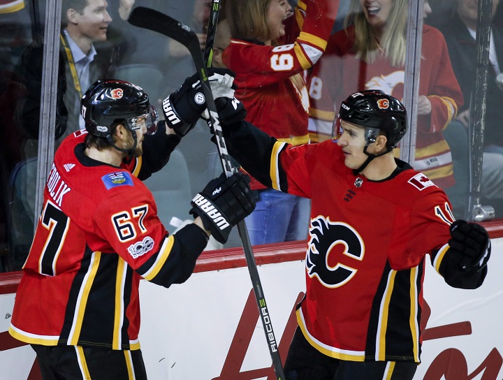 Calgary Flames' Michael Frolik, left, from the Czech Republic, celebrates his goal with teammate Mikael Backlund, from Sweden, during first period NHL hockey action against the San Jose Sharks in Calgary, Thursday, Dec. 14, 2017.