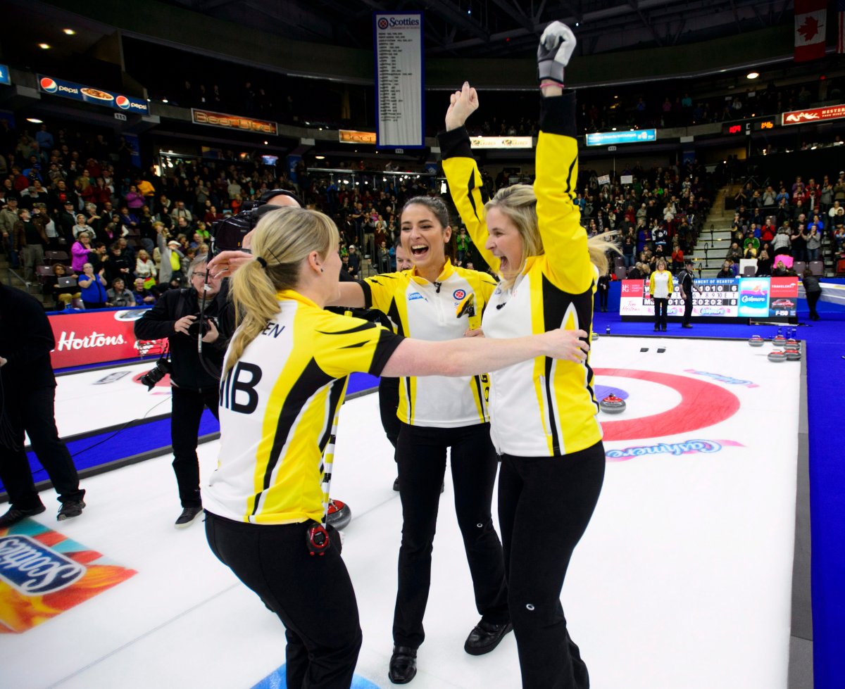 Manitoba, third, Shannon Birchard, middle, skip Jennifer Jones, right, and lead Dawn McEwen celebrate after defeating the Wild Card team to win the Scotties Tournament of Hearts in Penticton, B.C., on Sunday, Feb. 4, 2018. THE CANADIAN PRESS/Sean Kilpatrick.