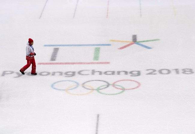 A worker walks across the Pyeongchang 2018 logo in the figure skating venue during the XXIII Olympic Winter Games in Gangneung, South Korea on Thursday, February 8, 2018. 