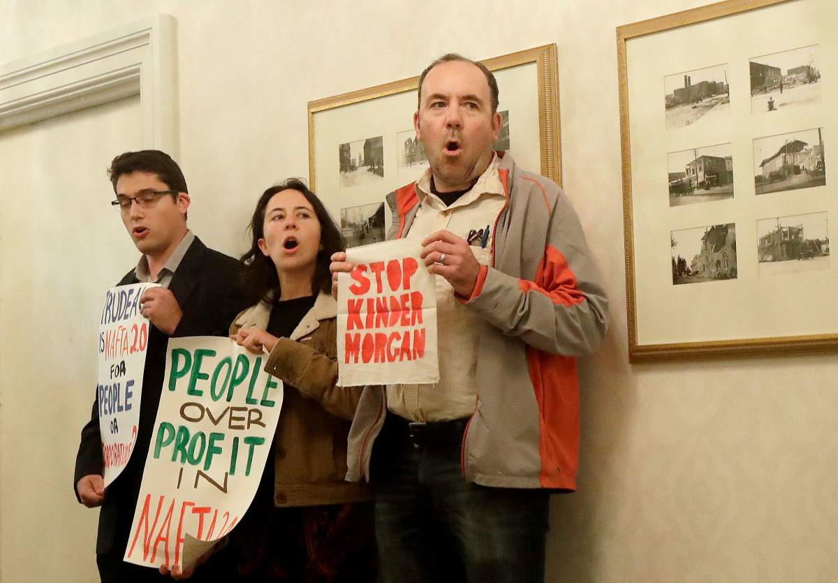 A trio of protesters yell outside of a meeting with Canada’s Prime Minister Justin Trudeau and California Gov. Jerry Brown in San Francisco, Friday, Feb. 9, 2018. (AP Photo/Jeff Chiu, Pool)