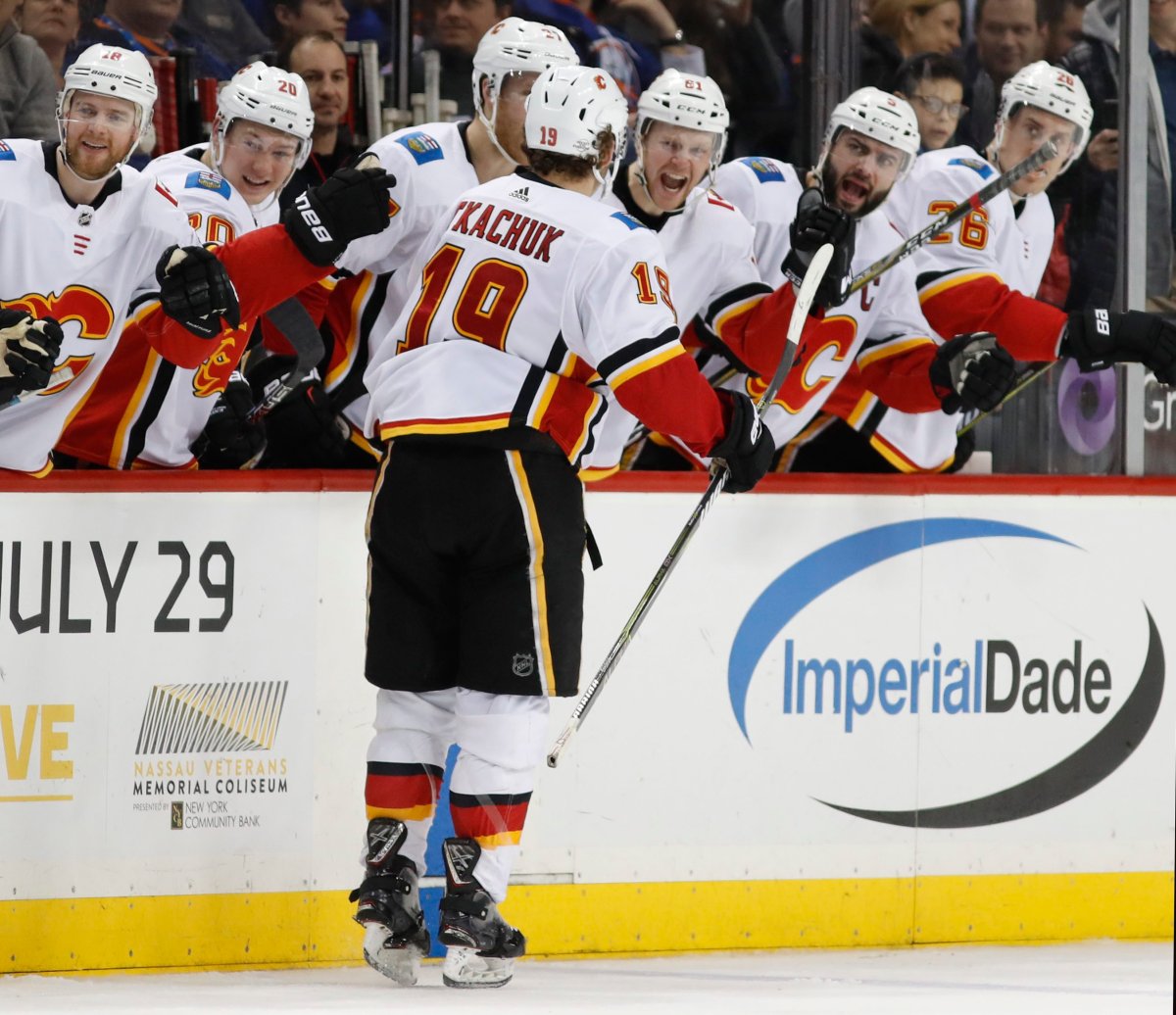 Teammates celebrate with Calgary Flames left wing Matthew Tkachuk (19) who scored two goals in the third period of an NHL hockey game against the New York Islanders in New York, Sunday, Feb. 11, 2018. The Flames defeated the Islanders 3-2 on Tkachuk's game-winning goal. (AP Photo/Kathy Willens).