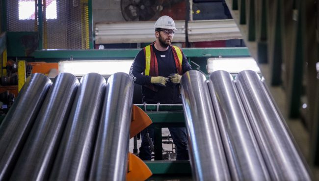 Employees monitor equipment at a company producing pipe, casing and tubing for the Canadian oil and gas sector in Calgary, Alta., Feb. 9, 2018. 