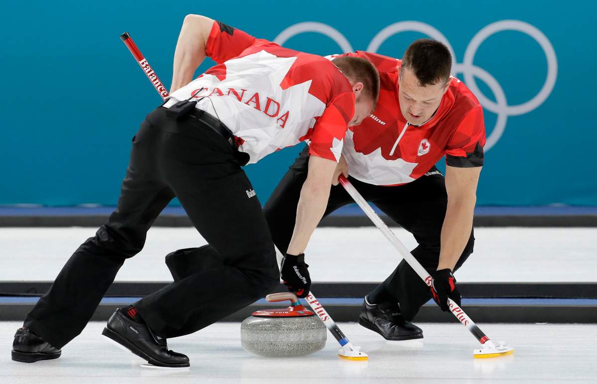 Canada’s Ben Herbert, right and Marc Kennedy sweeps ice during their men’s curling match against Sweden at the 2018 Winter Olympics in Gangneung, South Korea, Saturday, Feb. 17, 2018.