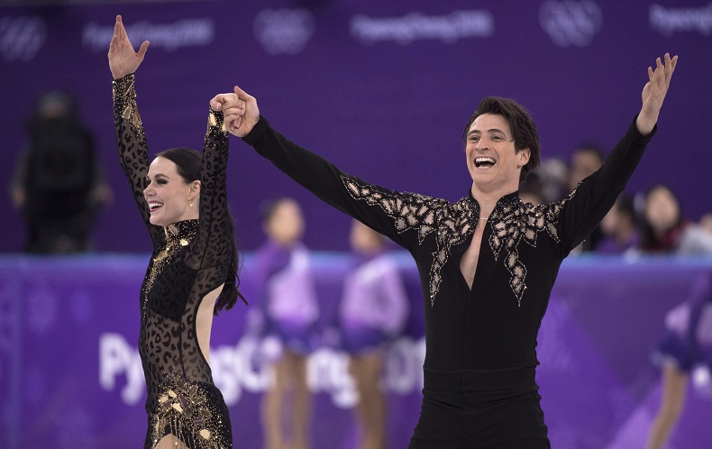 Canada’s Tessa Virtue and Scott Moir salute the crowd following their performance in the ice dance figure skating short program.
