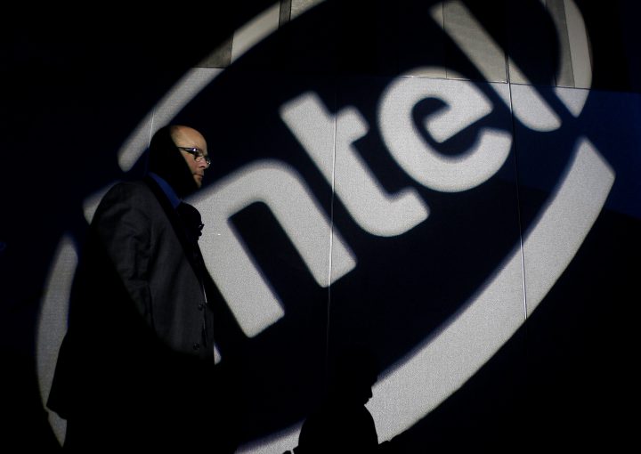 A man walks past an Intel logo.