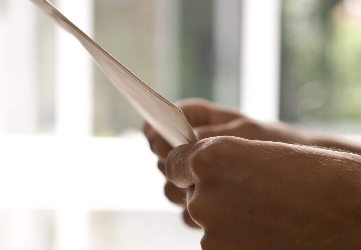 Close-up of hands holding an envelope.