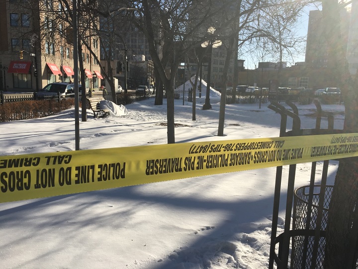 Police tape surrounds a downtown Winnipeg park after a body was found on a bench Thursday.