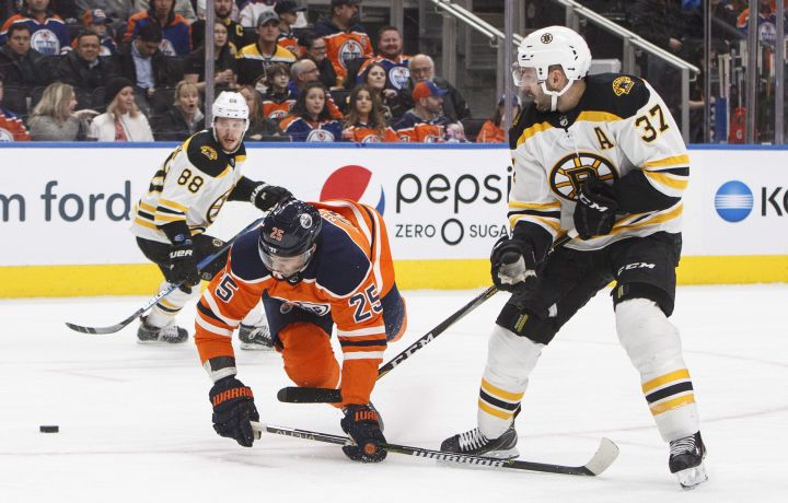 Boston Bruins' Patrice Bergeron (37) and Edmonton Oilers' Darnell Nurse (25) battle for the puck during first period NHL action in Edmonton, Alta., on Tuesday February 20, 2018. 