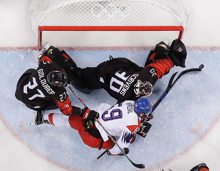 Canada’s Ben Scrivens and Lukas Radil of the Czech Republic battle for the puck during the first period of the preliminary round of the men's hockey at the 2018 Winter Olympics in Gangneung, South Korea, Feb. 17, 2018. 