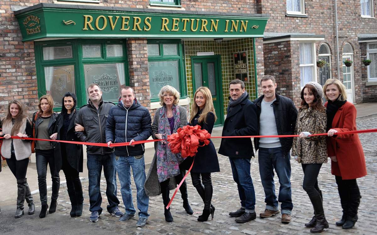 Actress Sue Nicholls cuts a ribbon with 'Coronation Street' cast members to open the Coronation Street set on November 29, 2013 in Manchester, England. 