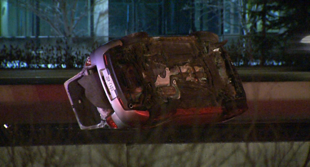 A vehicle, riddled with bullet holes, sits overturned in the Eastbound lanes of Highway 401 near Winston Churchill Boulevard.
