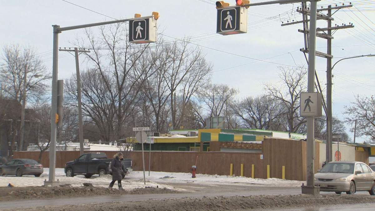 A pedestrian crosses at a controlled corridor across a busy Winnipeg street in this file photo from February 2018.